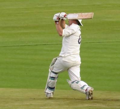 A person wearing a white uniform and holding a bat

Description automatically generated with low confidence