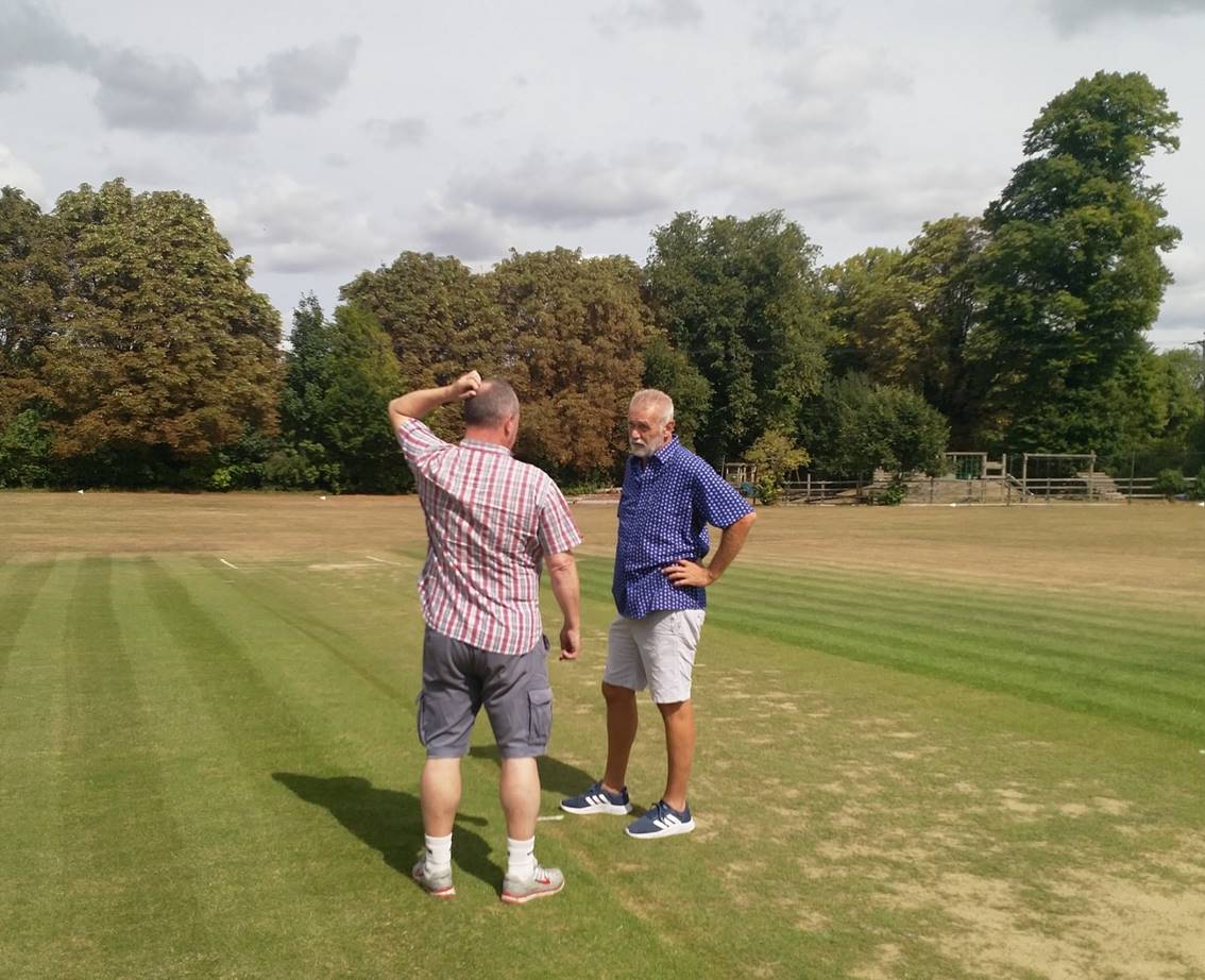 Two men standing on a golf course

Description automatically generated with medium confidence