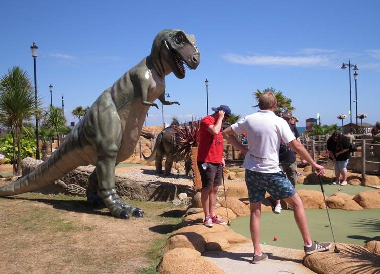 A group of people looking at a statue of a dinosaur

Description automatically generated with low confidence