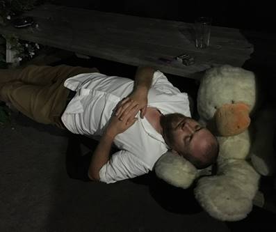 A person lying on a couch next to a stuffed bear

Description automatically generated with low confidence