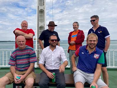 A group of men posing for a photo on a boat

Description automatically generated with medium confidence