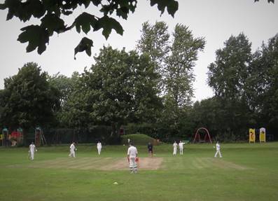 A group of people playing cricket

Description automatically generated