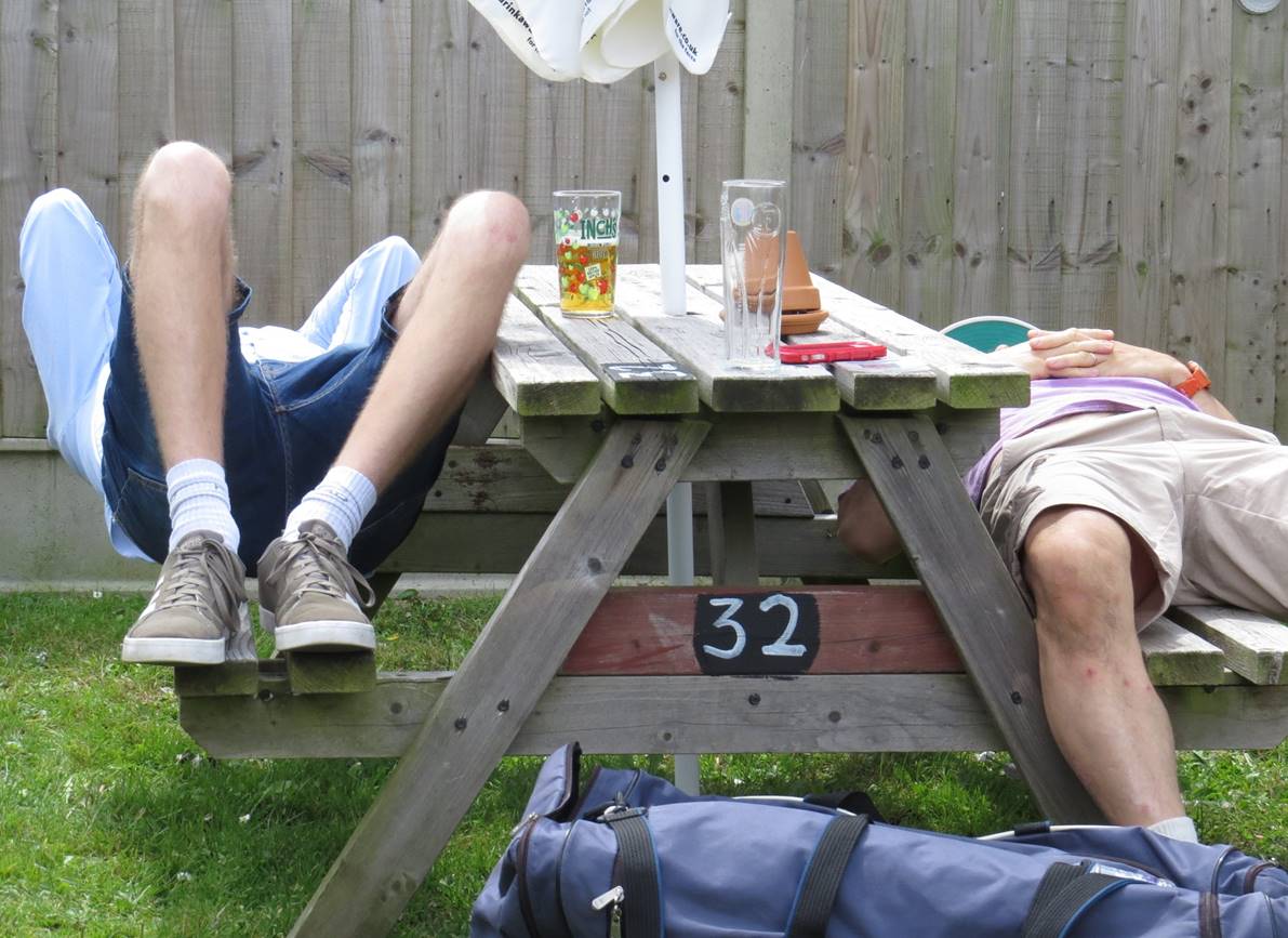 Two people lying on a picnic table

Description automatically generated with medium confidence